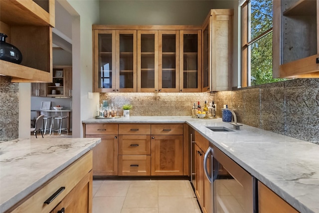 kitchen featuring wine cooler, light tile patterned floors, light stone counters, sink, and tasteful backsplash