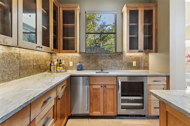 bar with beverage cooler, refrigerator, light tile patterned flooring, and light stone countertops