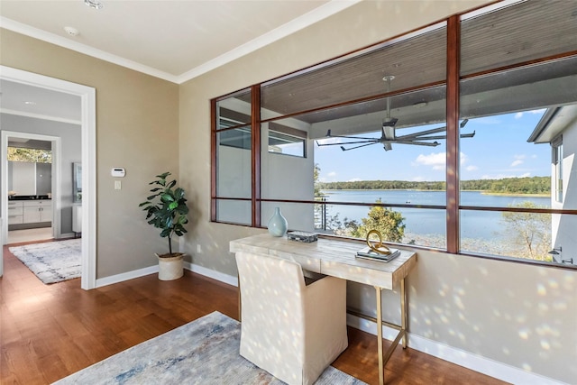 office with wood-type flooring, ornamental molding, and a water view