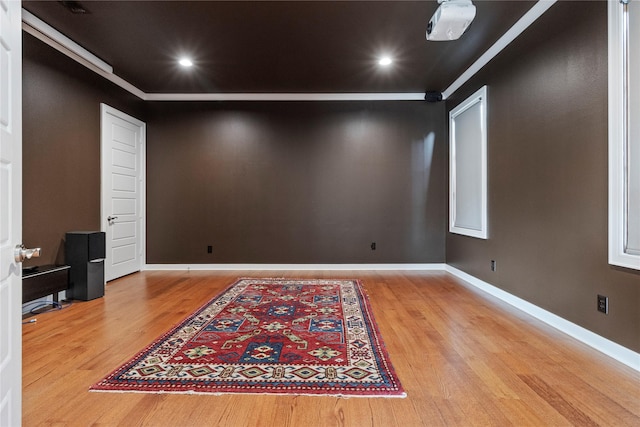 empty room with crown molding and wood-type flooring