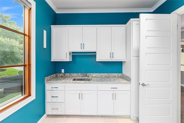 kitchen featuring sink, a healthy amount of sunlight, white cabinetry, and light stone countertops