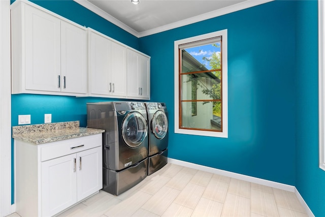 laundry room with washer and dryer, cabinets, and crown molding