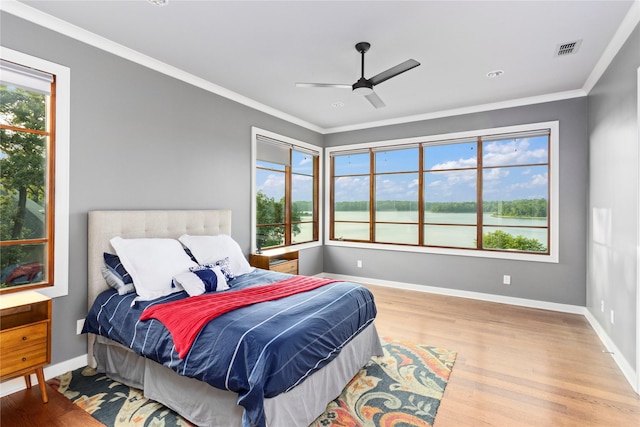 bedroom featuring ceiling fan, light wood-type flooring, and ornamental molding