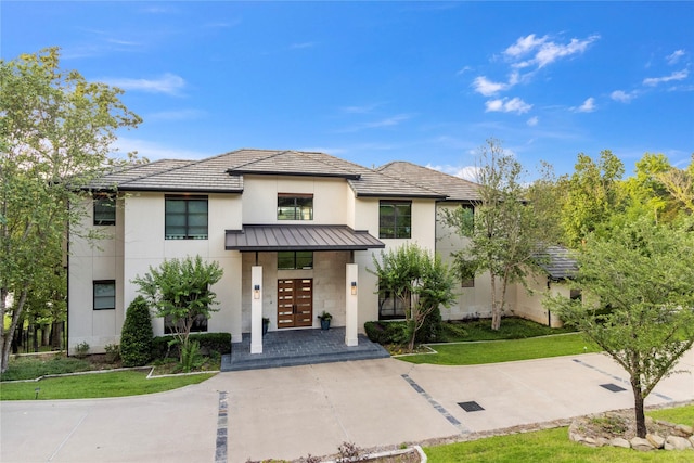 view of front of house with french doors and a front lawn