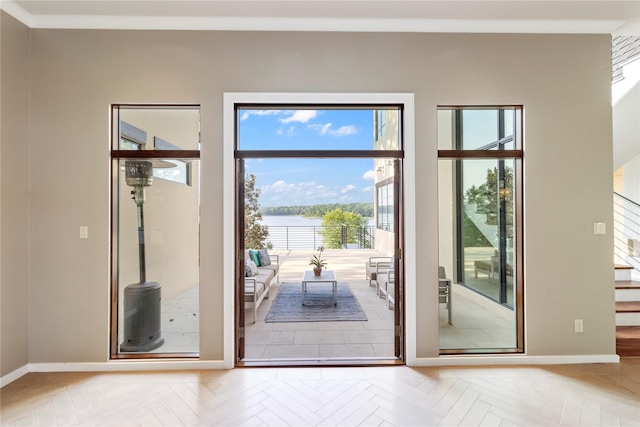 doorway to outside with light parquet floors, a wealth of natural light, and a water view