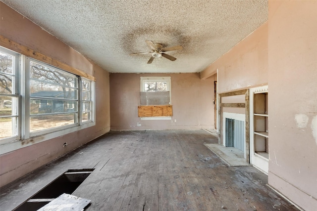 unfurnished living room with a textured ceiling and ceiling fan