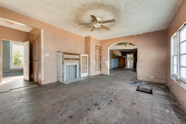 unfurnished living room with a textured ceiling, ceiling fan, and hardwood / wood-style floors