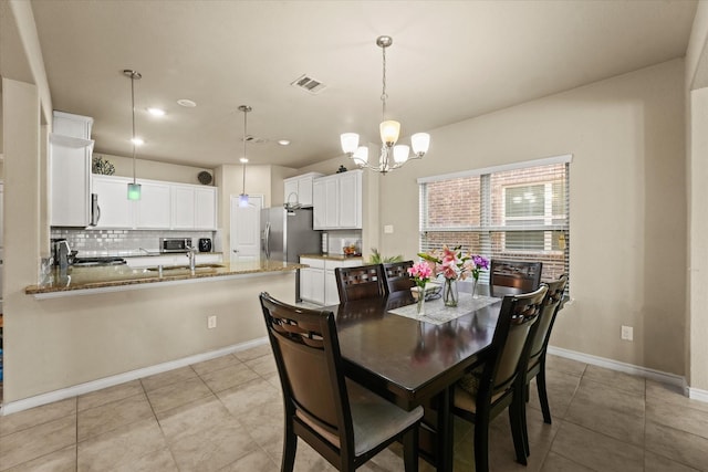 dining space featuring a notable chandelier and light tile patterned flooring