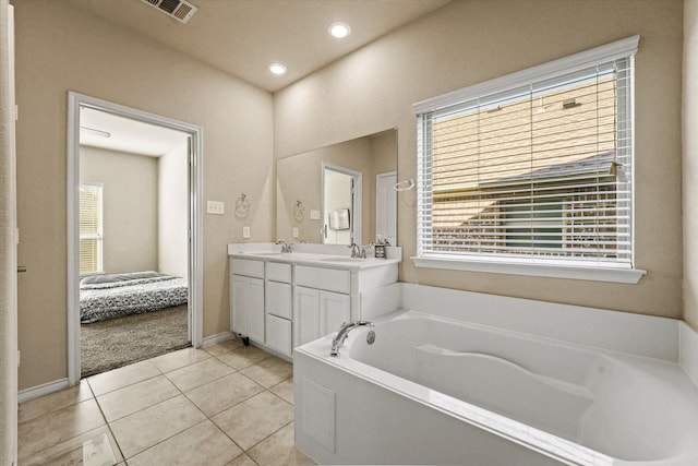 bathroom featuring a washtub, tile patterned flooring, a wealth of natural light, and vanity