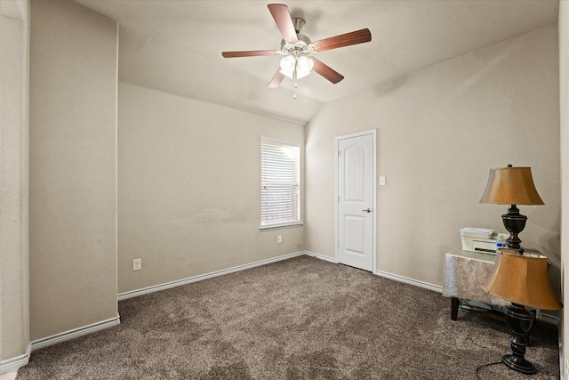 unfurnished office featuring lofted ceiling, dark colored carpet, and ceiling fan