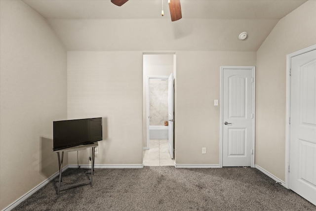 bedroom featuring ceiling fan, ensuite bathroom, light carpet, and lofted ceiling