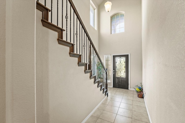 foyer entrance featuring a high ceiling and light tile patterned flooring