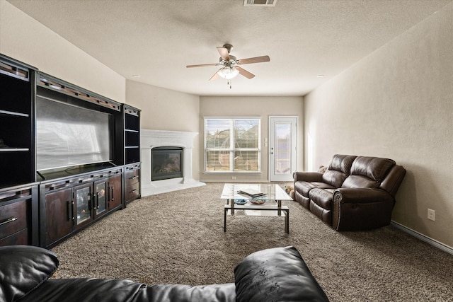 carpeted living room with a textured ceiling and ceiling fan