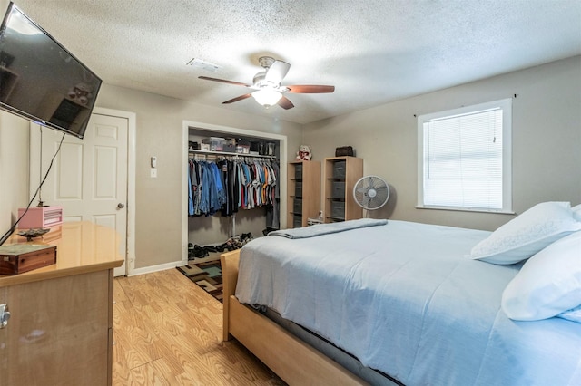 bedroom with a closet, ceiling fan, a textured ceiling, and light hardwood / wood-style flooring