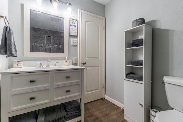 bathroom featuring toilet, vanity, and hardwood / wood-style flooring