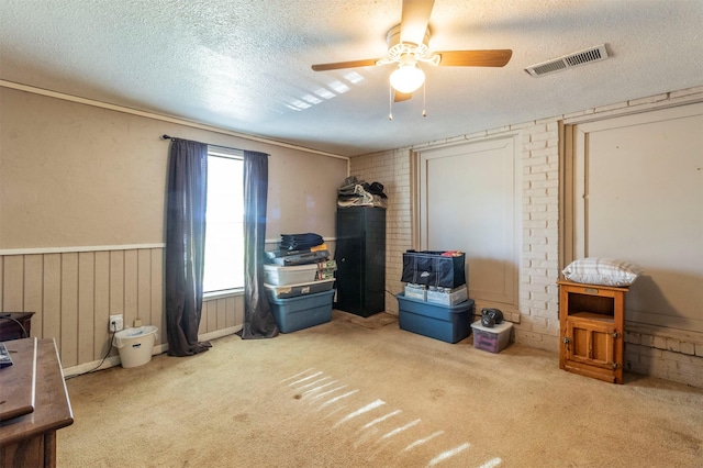 misc room with a textured ceiling, ceiling fan, and carpet floors