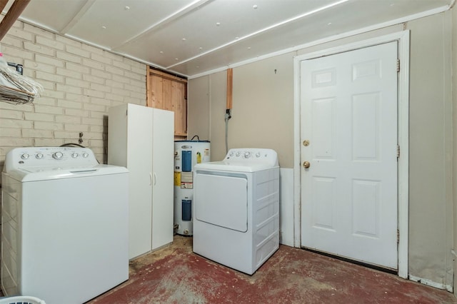 washroom featuring washer and dryer, water heater, and cabinets