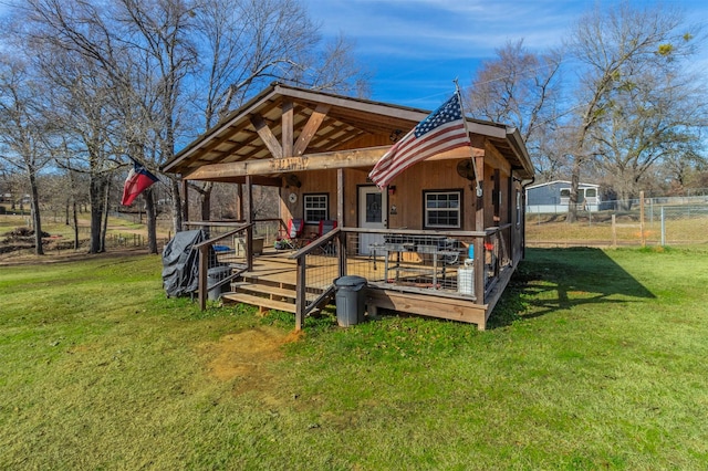 rear view of house with a lawn, a deck, and an outdoor structure