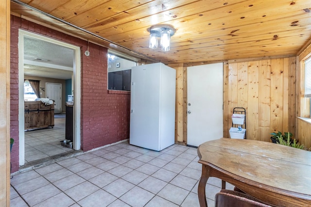 interior space with wooden walls, wooden ceiling, brick wall, and light tile patterned floors