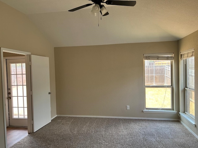 carpeted spare room featuring ceiling fan, lofted ceiling, and a textured ceiling