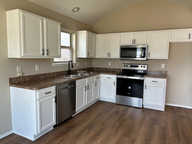 kitchen with sink, white cabinets, vaulted ceiling, dark hardwood / wood-style flooring, and appliances with stainless steel finishes