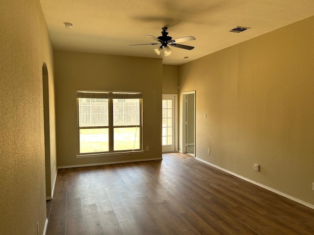 empty room featuring a textured ceiling, ceiling fan, and dark hardwood / wood-style floors