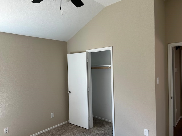 unfurnished bedroom featuring a closet, ceiling fan, vaulted ceiling, and carpet floors