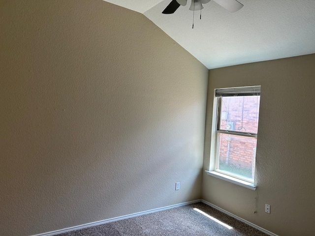 carpeted spare room with ceiling fan and vaulted ceiling