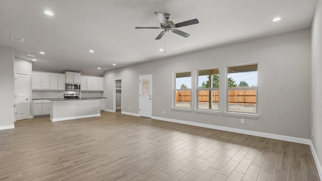 unfurnished living room with ceiling fan