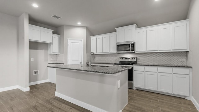 kitchen featuring stainless steel appliances, a center island with sink, white cabinets, and sink