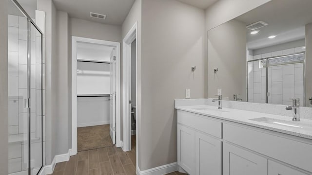 bathroom featuring walk in shower and vanity