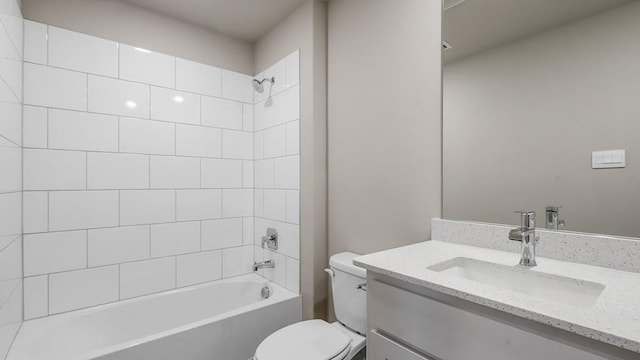 full bathroom featuring tiled shower / bath combo, vanity, and toilet