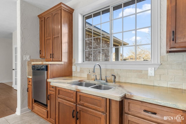 kitchen featuring sink, dishwasher, and light tile patterned flooring