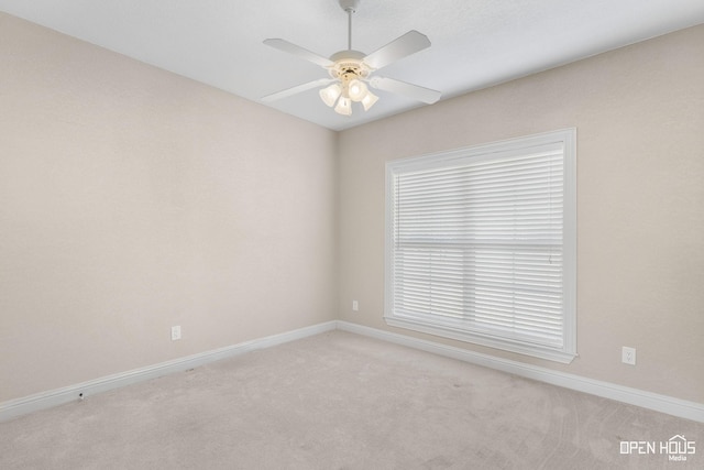 empty room featuring a healthy amount of sunlight, ceiling fan, and light carpet