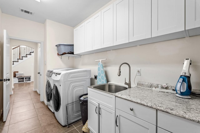 laundry room with sink, tile patterned floors, separate washer and dryer, and cabinets