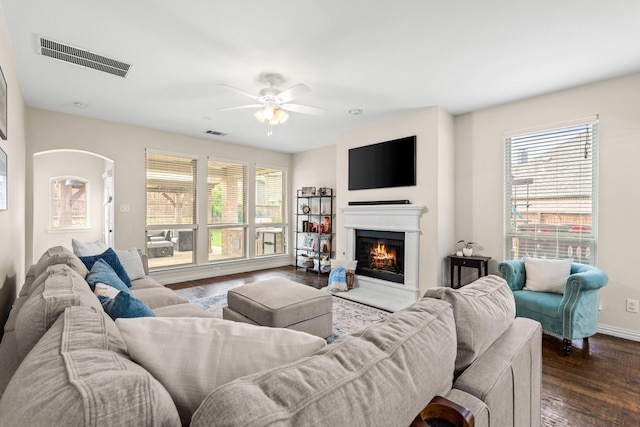 living room with ceiling fan, a healthy amount of sunlight, and dark wood-type flooring