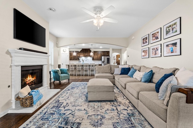 living room featuring ceiling fan and dark hardwood / wood-style flooring