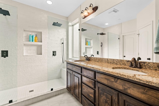 bathroom featuring a tile shower and vanity