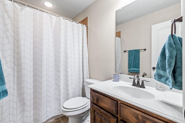 bathroom featuring toilet, vanity, and tile patterned flooring