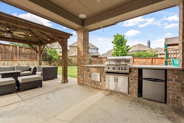 view of patio with sink, an outdoor living space, grilling area, a gazebo, and exterior kitchen