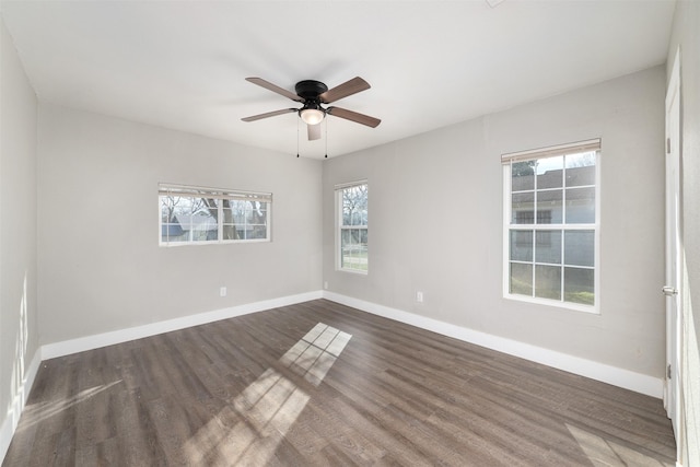 spare room featuring dark wood-type flooring, ceiling fan, and plenty of natural light