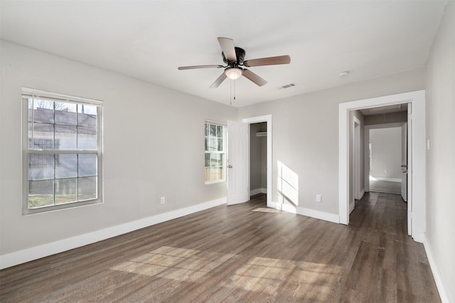 unfurnished bedroom featuring dark hardwood / wood-style flooring, multiple windows, and ceiling fan