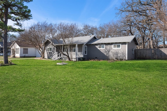 rear view of house with covered porch and a lawn