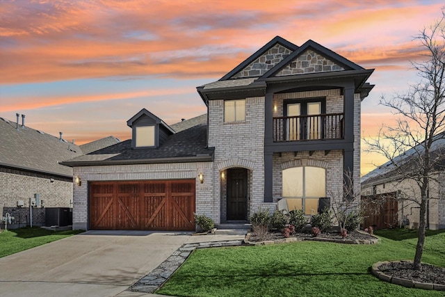 view of front of home with a balcony, a garage, cooling unit, and a lawn