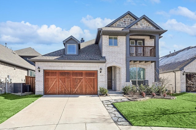 view of front of property featuring a garage, a balcony, and a front yard