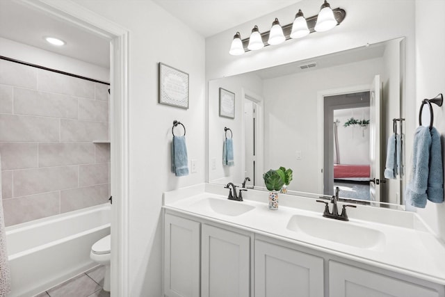 full bathroom with toilet, tiled shower / bath combo, tile patterned flooring, and vanity