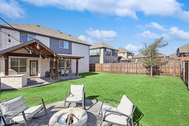 back of house with a lawn, a fire pit, and a patio area