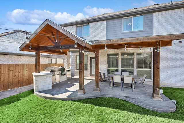 rear view of property with a patio area, a yard, and area for grilling