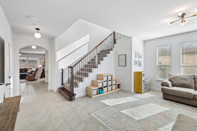 living room with ceiling fan, light tile patterned floors, and a healthy amount of sunlight