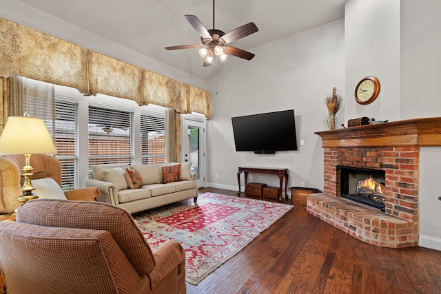 living room with ceiling fan, lofted ceiling, dark hardwood / wood-style flooring, and a brick fireplace